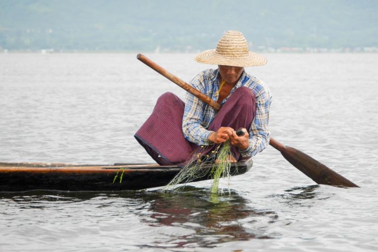 Rybak w longyi nad jeziorem Inle