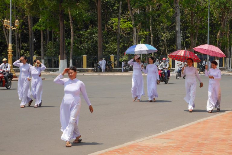 Kobiety w białych ao dai idą do świątyni kaodaistycznej